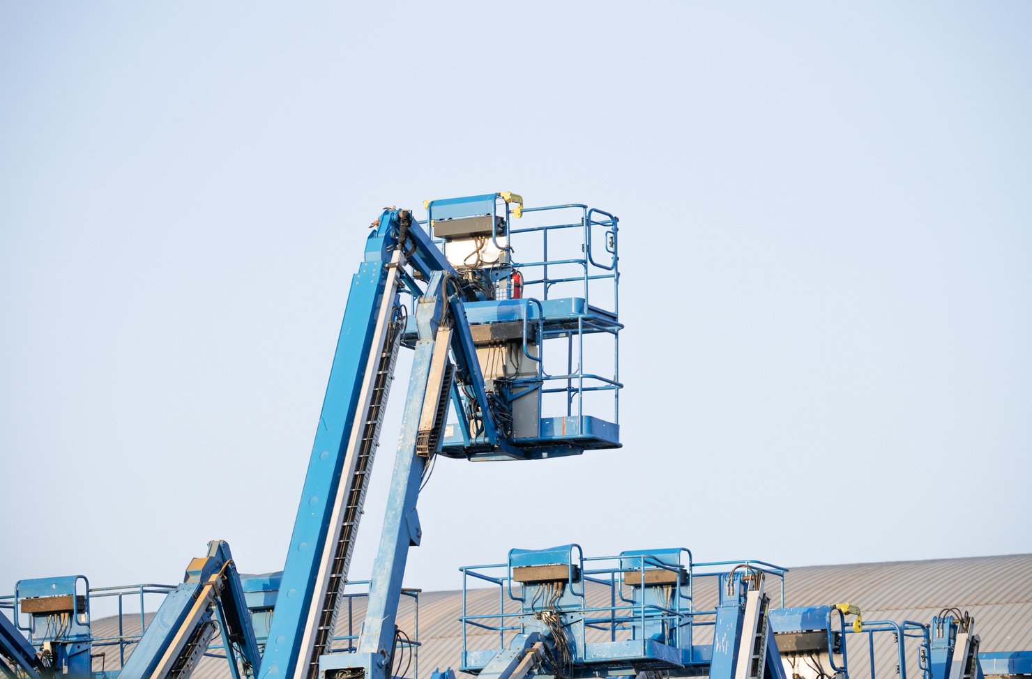 Articulated boom lift. Aerial platform lift. Telescopic boom lift against clear sky. Mobile construction crane for rent and sale. Maintenance and repair hydraulic boom lift service. Crane dealership.